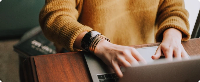 Woman typing sending money on her laptop